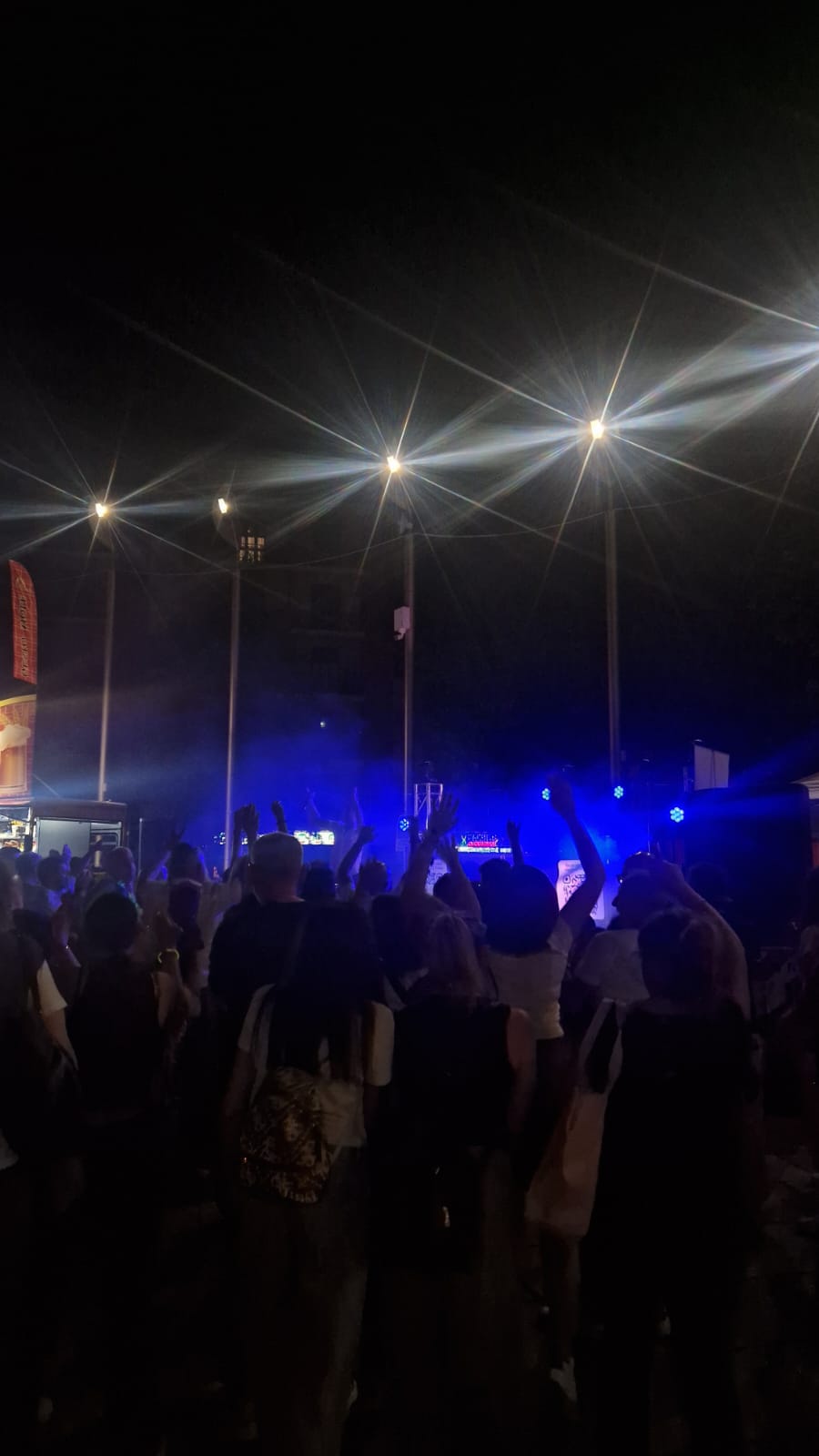 Folla a un raduno serale all'aperto con luci blu